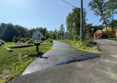 A newly paved residential driveway marked off with yellow caution tape.
