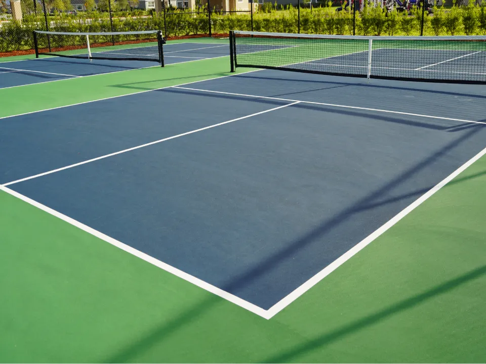 An empty pickleball court with blue and green surfaces and a central net.